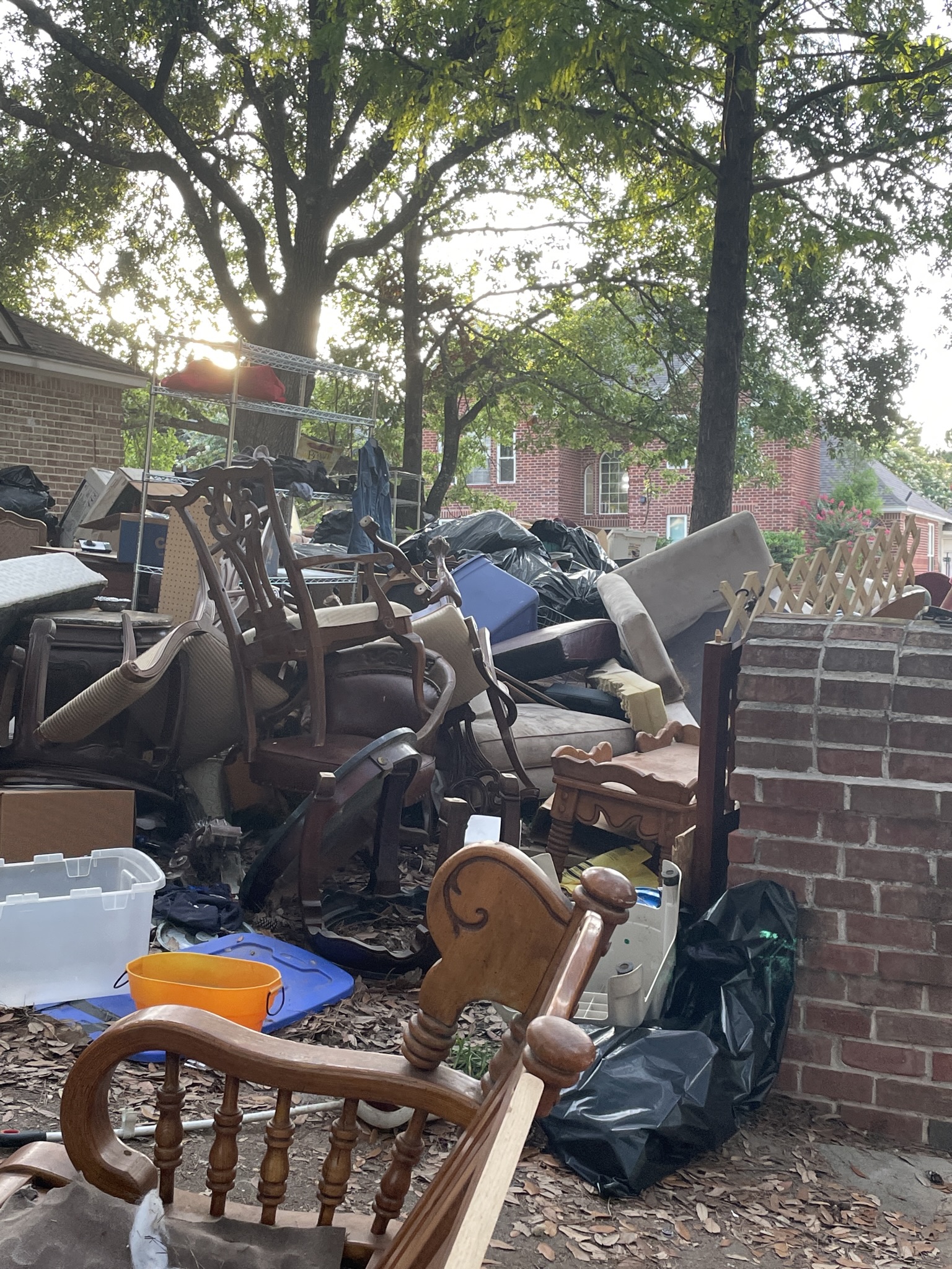 Picture of furniture and garbage piled outside on a yard.