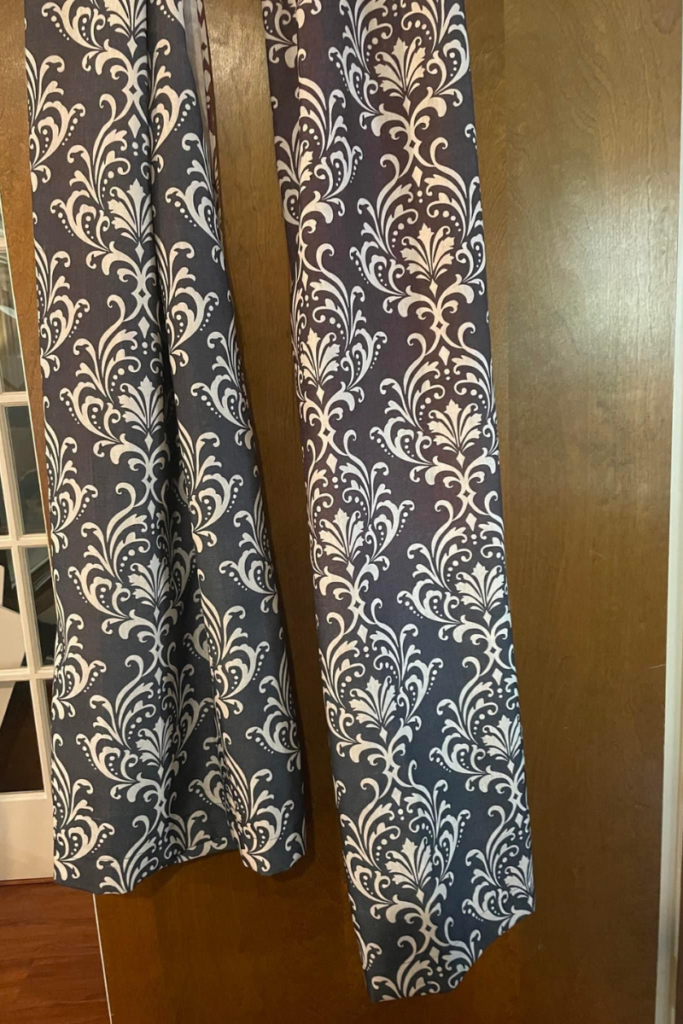 Blue and white shower curtains hanging over a door. Upcycled shower curtains to upholster curbside find chairs easy makeover